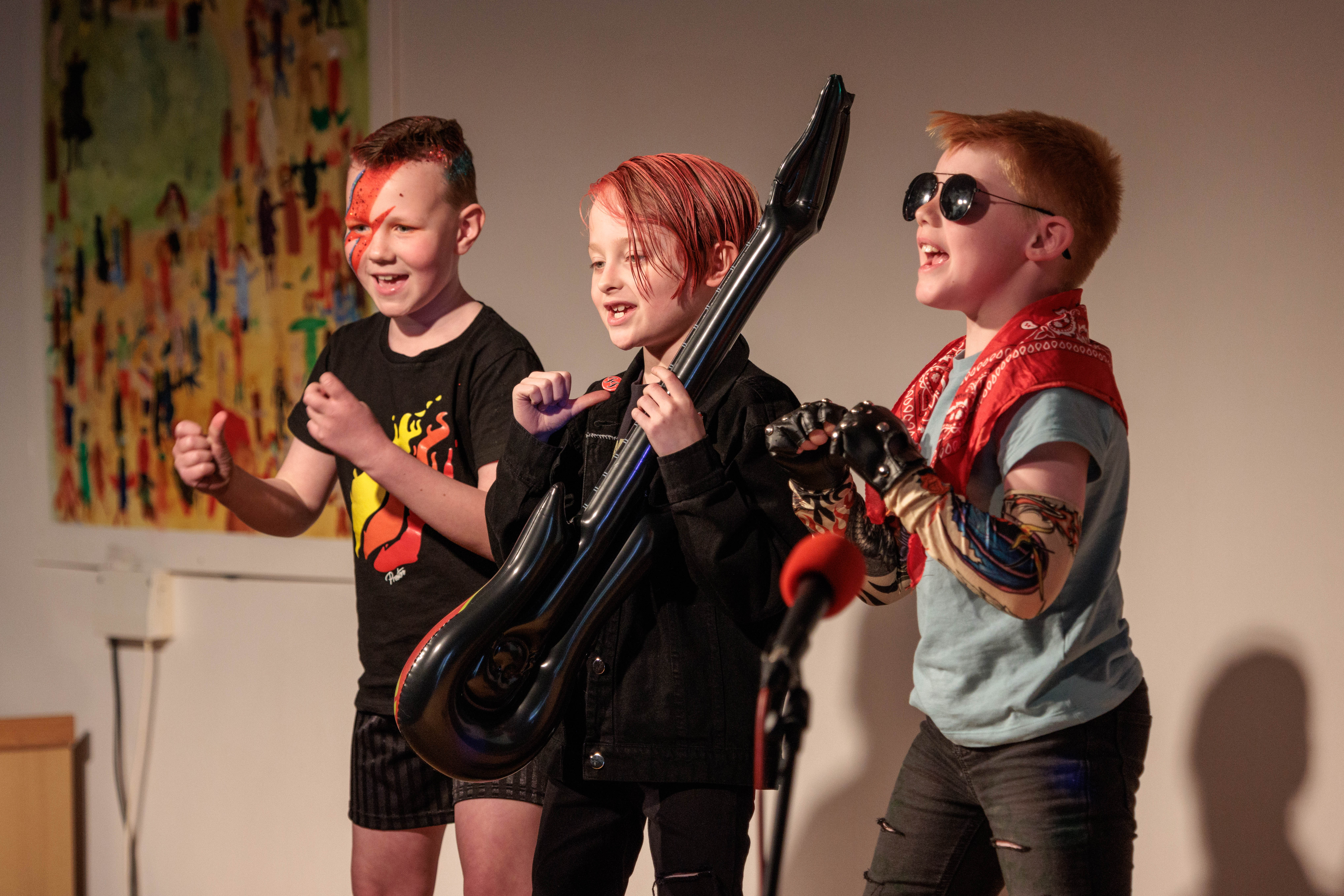 Photo of children dressed as rock stars performing their rap